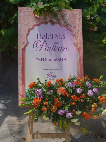 Personalized details make an event truly special. This elegant welcome signage, with its beautiful calligraphy and fresh floral base, greeted guests with the warm message 'Haldi Ma Padharo' for a traditional Rajasthani themed event.