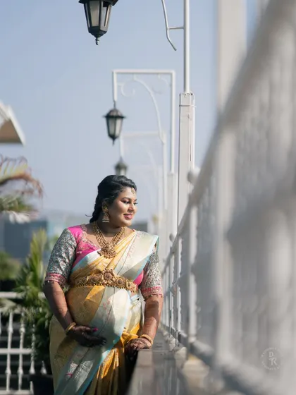 A lovely outdoor portrait of a mother-to-be on a balcony, looking out with a gentle smile, dressed in traditional attire for her baby shower.