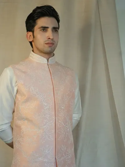 Unleash the power of floral elegance with our exquisite peach silk jacket, adorned with intricate floral dori work for a soft, romantic look.