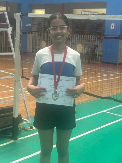 One of our dedicated students proudly displaying her medal and certificate after a successful school tournament. We support players at all levels of competition.