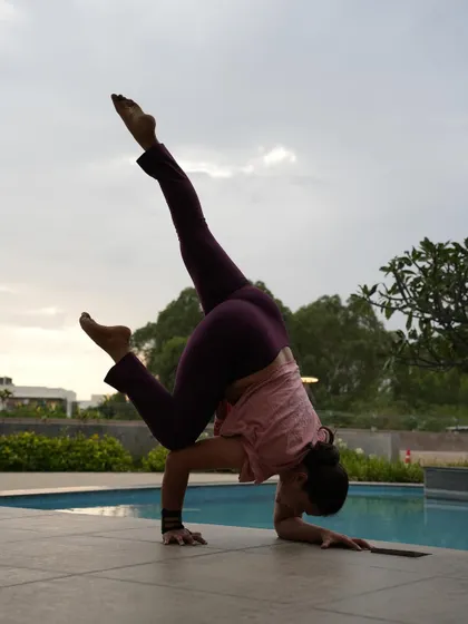 A funky Pincha Mayurasana variation, playing with a stag leg position. This not only challenges balance but also adds an element of creativity to the inversion practice.
