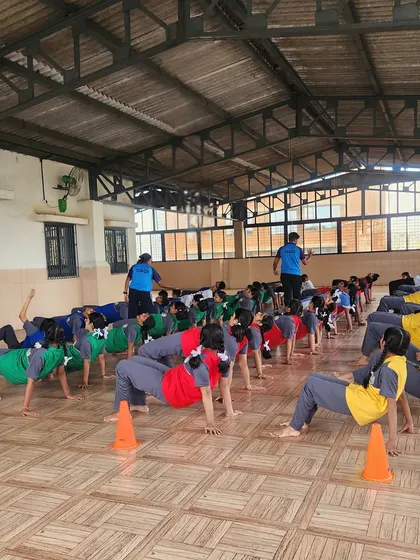 Students perform the reverse tabletop pose in a synchronized yoga class. These exercises are excellent for building core and arm strength in a controlled manner.