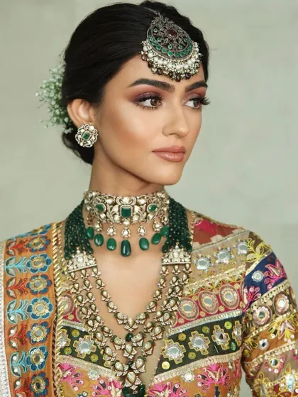 A colorful and vibrant mehendi look. The makeup features a subtle smokey eye that complements the multi-tonal outfit without competing with it.