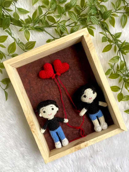 This custom frame features a replica doll couple holding red heart balloons, symbolizing their love. It's a heartfelt, personalized gift that tells a couple's story through handmade art.