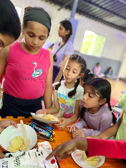 The moment of truth: cutting the cake. All eyes are on the treats as the kids wait patiently for their share.