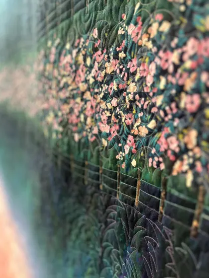 A detail shot of the scenery quilt, where the quilting follows the lines of the trees to add depth.