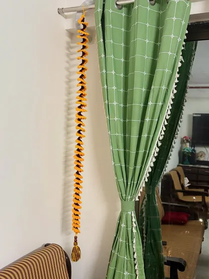 A long, spiral crochet wall hanging in yellow and brown with a tassel at the end, perfect for adding a touch of bohemian decor.