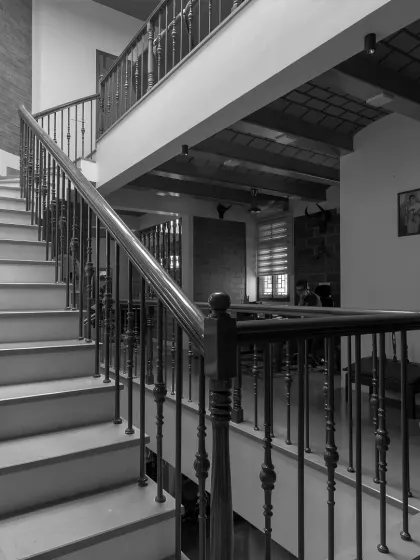 A low-angle view of the staircase, emphasizing its structural form and the different levels it connects within the open-plan home.