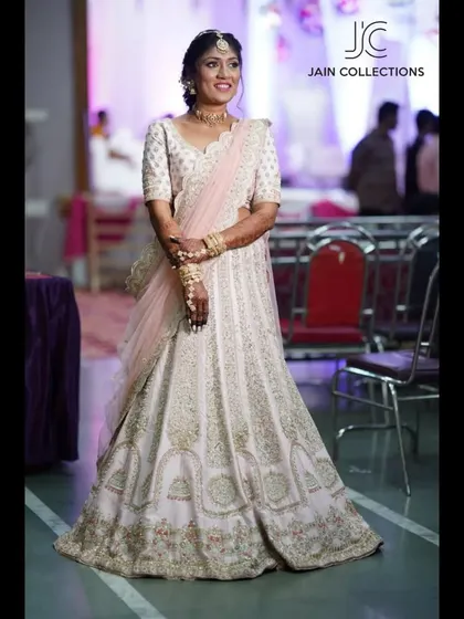A client looking beautiful in a white and gold lehenga, which is part of my collection that is often available for sale, rent, or custom design.