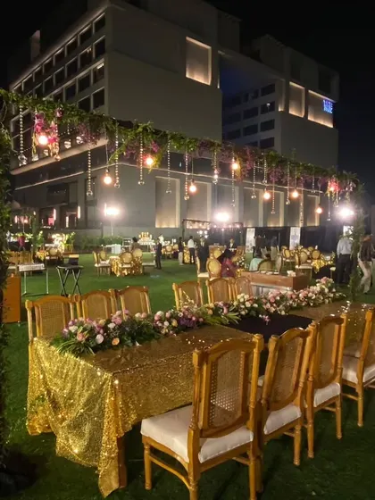 The outdoor seating for the corporate ceremony was designed for elegance and comfort. I used long tables with gold sequin runners, beautiful floral centerpieces, and classic wooden chairs to create a sophisticated dining area.
