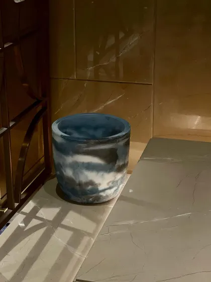 Even planters can be accent pieces. This handmade planter features a unique, marbled color pattern created during the concrete casting process, turning a simple utility item into a piece of decor.