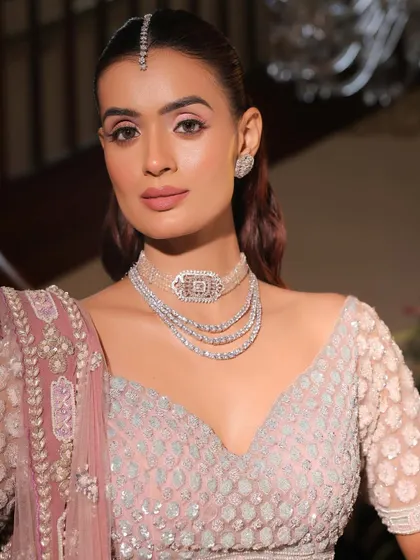 A close-up on the monochrome pink makeup. The soft pink on the eyes, cheeks, and lips creates a harmonious and romantic look, enhanced by the sparkle of diamond jewellery.