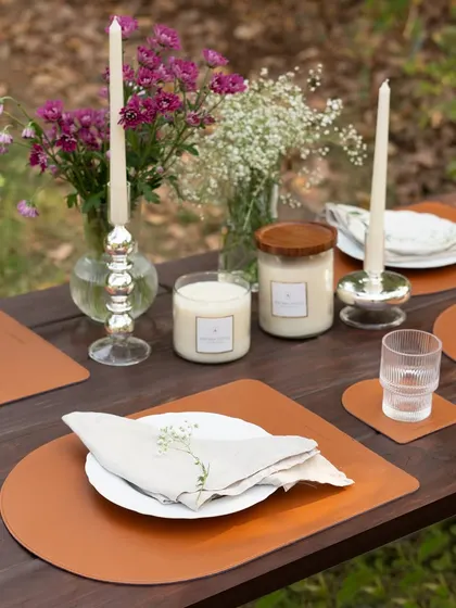 Elevate your gatherings with layers of light. This outdoor tablescape shows how our simple glass jar candles and elegant taper candles can work together to transform a simple meal into a magical, memorable experience.