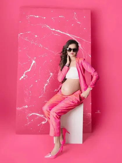 Who says maternity can't be high fashion? This mom-to-be is rocking a bold pink pantsuit, showing that you can embrace your personal style, whether it's glam, chic, or modern, during your pregnancy photoshoot.