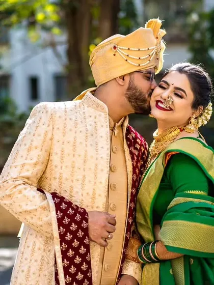A sweet and spontaneous moment as the groom gives his bride a kiss on the cheek during their outdoor portrait session.