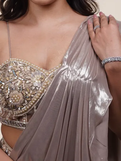 A close-up of the blouse on this metallic saree. The intricate beadwork and pearl details create a luxurious texture that looks incredible up close.