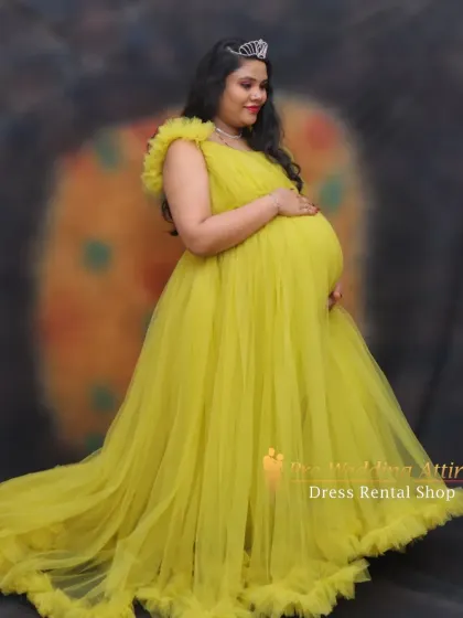 Accessorized with a tiara, our yellow ruffled gown helps create a true princess moment. This studio shot shows how the gown drapes beautifully, perfect for elegant and classic maternity portraits.