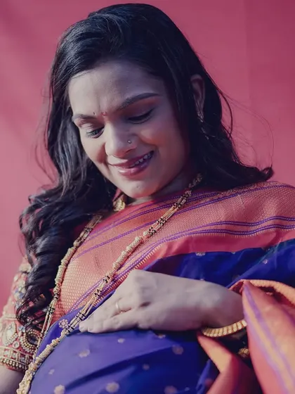 A close-up shot capturing the beautiful glow of motherhood. The traditional attire adds so much grace.
