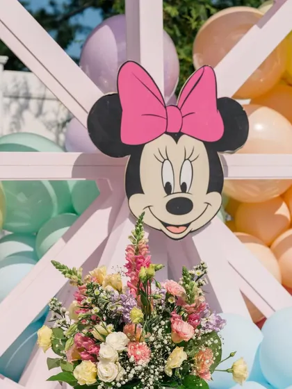 A sweet detail shot of a Minnie Mouse head on the wheel prop, with a fresh floral arrangement below.