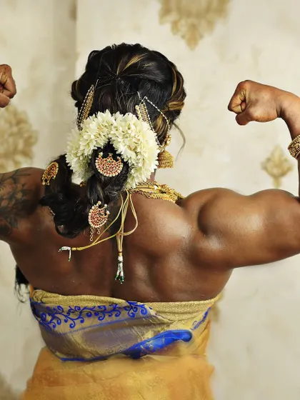 A powerful back double-bicep pose in a saree. This is a classic bodybuilding pose, redefined with traditional elegance, showing my well-developed back muscles.