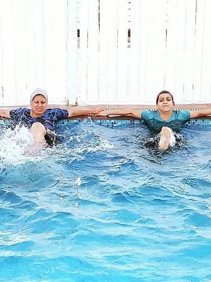 Here, the class is performing flutter kicks while holding the side of the pool. This is an excellent low-impact exercise for strengthening the core and leg muscles.