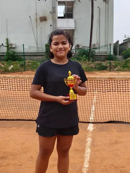 Lawan Roy, our Girls Under 14 Champion, proudly holding her trophy. Her success is a result of her commitment to training and her performance in competitive matches.