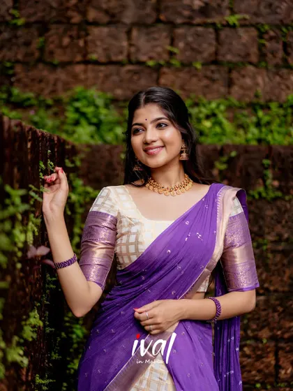 Modeling a beautiful Onam-themed half-saree in off-white and maroon. The simplicity of the design and the tranquil location create a feeling of peaceful celebration.