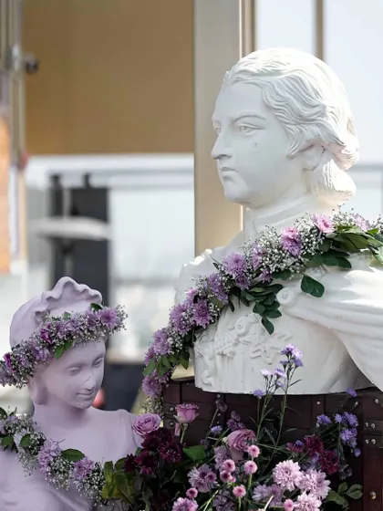 Classic Victorian-style busts adorned with fresh flower garlands, perfectly merging the two cultures for this fusion wedding.