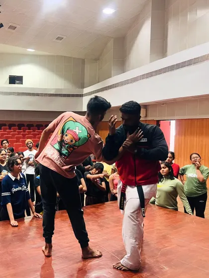 On stage at NIFT, I explain the principles of blocking and parrying as part of our traditional karate self-defense training.