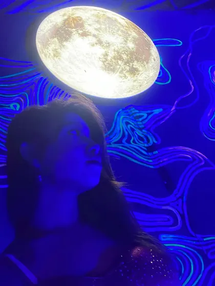 A cool shot under a moon installation at a club. The right decor and lighting can completely change the mood and elevate the entire night.