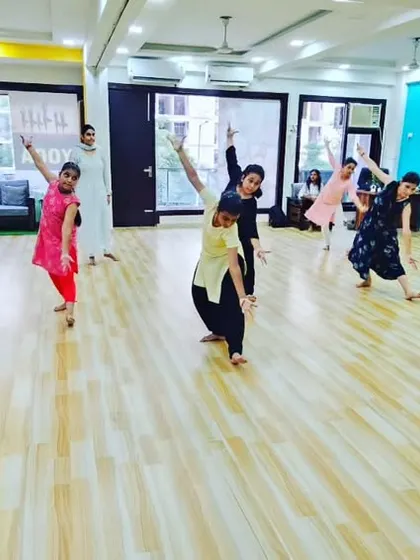 A dynamic moment in our adult Bharatanatyam class, with students practicing a sequence that involves graceful turns and poses.