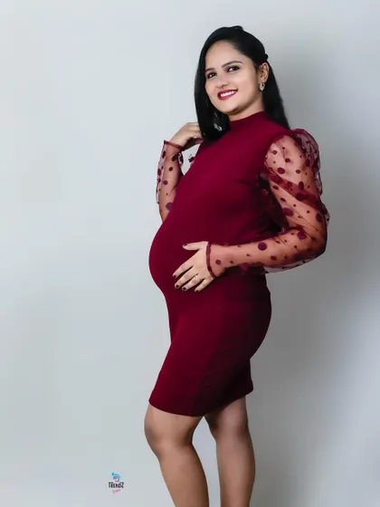 A modern and chic studio look. This couple chose matching burgundy outfits for a stylish and contemporary maternity portrait series.