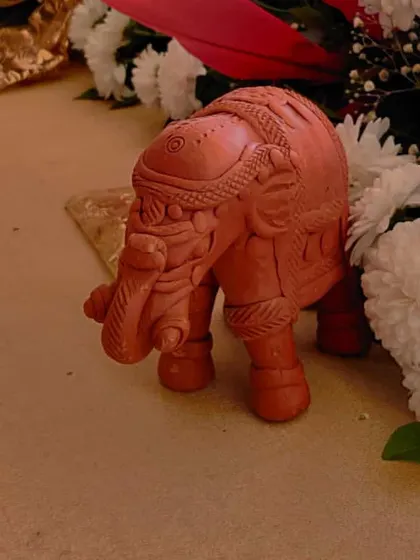 A small terracotta elephant figurine used as part of the table decor. These little details add character and a touch of Indian tradition to the overall design.