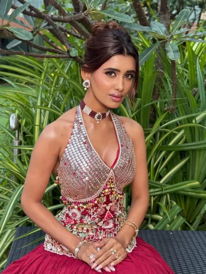 A seated portrait of the modern Garba Night look. The intricate details of the outfit are balanced by the clean, glowing makeup.