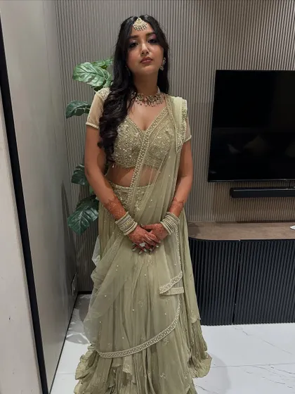 A full portrait of this bride-to-be in her muted olive lehenga. The soft makeup and hair create a sophisticated and modern look.