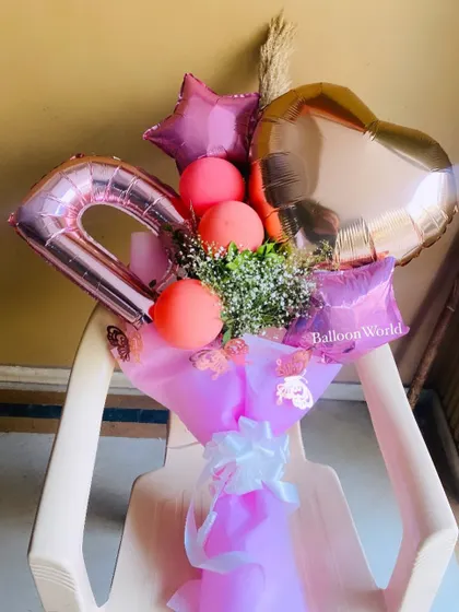 This hand bouquet combines foil balloons in different shapes with latex balloons and dried pampas grass for a unique, textured look.