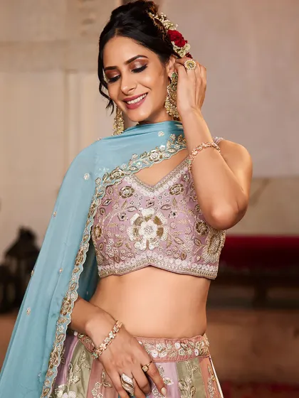 A close-up of the model's happy expression and the detailed blouse of the pastel panelled lehenga.