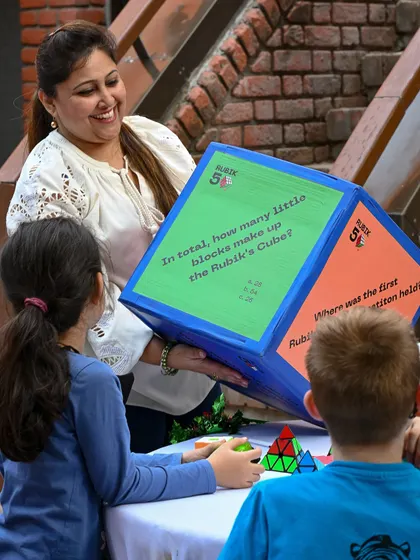 A woman engages children with a large Rubik's Cube game at the Charity Mela. Our festivals are filled with interactive games and educational fun for the whole family.