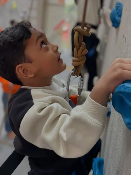 A close up of a young boy learning to grip the holds. Our coaches teach kids the proper techniques to climb efficiently and safely from their very first session.