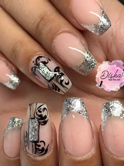 A stunning set of silver glitter French tips with intricate black and silver stamped designs.