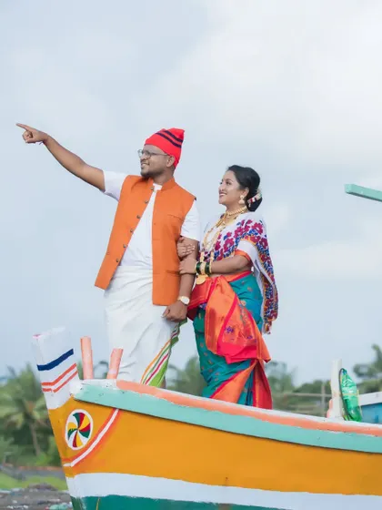 A pre-wedding shoot with a traditional Koli theme. The couple stands proudly on a fishing boat, celebrating their cultural heritage in a unique and beautiful way.