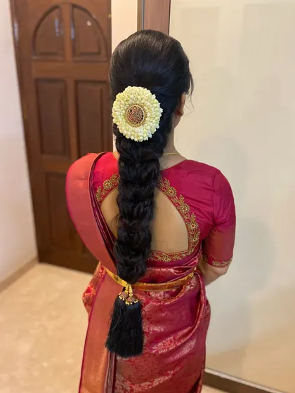 A clean and elegant South Indian braid, perfect for any ceremony. The look is completed with a jasmine floral arrangement and a traditional kunjalam (tassel) at the end of the plait.