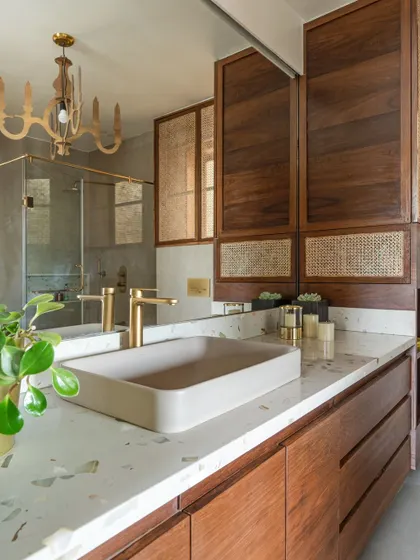 Another angle of the bathroom, showing the spacious glass shower enclosure and brass fixtures.