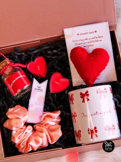 A sweet and simple hamper for her, featuring a cute mug, a satin scrunchie, heart-shaped candles, and a 'pocket hug'.
