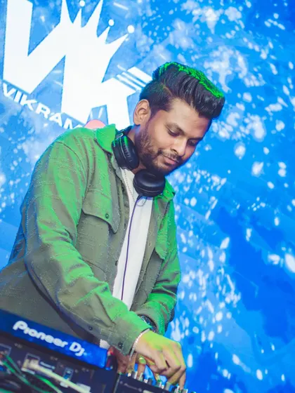 Focused on the mix. A clear, professional shot of me at the DJ booth against the backdrop of my logo.