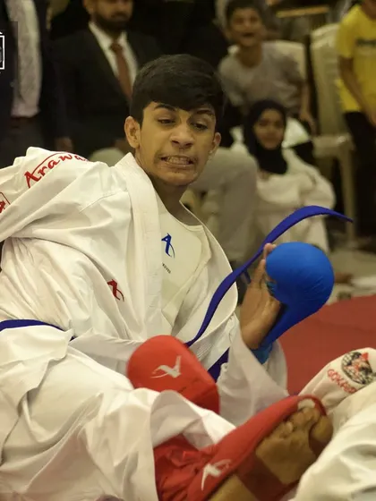 An intense action shot of a student executing a powerful kick during a close-fought kumite match. Every point is earned through skill and determination.