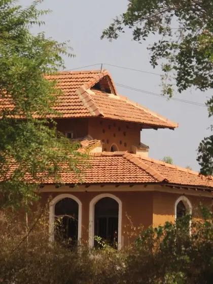 The Doddaballapura mud house seen through the trees. Our goal is to create homes that feel like a natural part of their environment, blending in rather than standing out.
