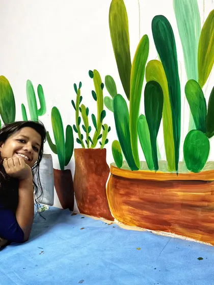 A fun photo of me with the cactus mural. The variety of shapes and sizes of the cacti and pots makes the wall visually interesting.