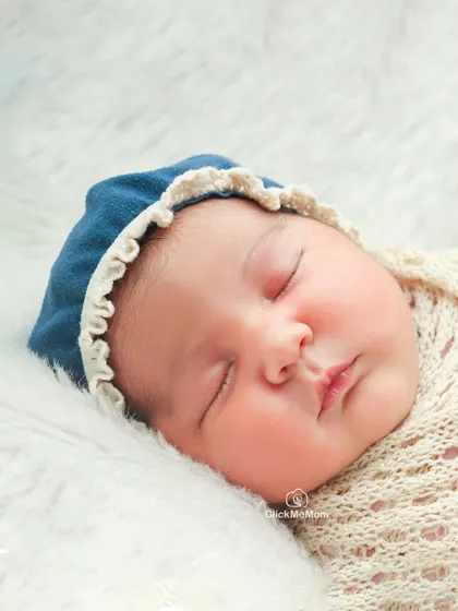 A close-up portrait of a newborn's face, with a simple blue bonnet framing their features. This shot is all about capturing their pure and innocent expression.