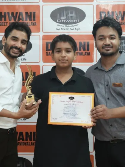 Two teachers present an award to their student.